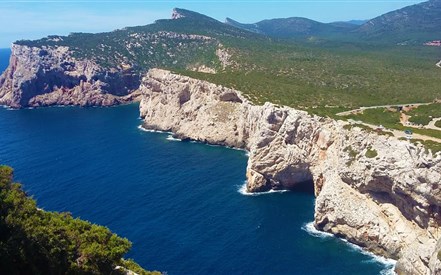 Porto Conte - Pohled z jeskyně Grotte di vasi rotti na pobřeží parku Porto Conte