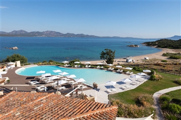 Pohled na bazén a pláž z hotelu, Li Cuncheddi, Sardinie