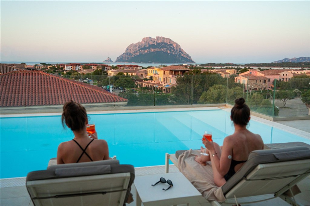 Pohled od bazénu s lehátky, Porto San Paolo, Sardinie